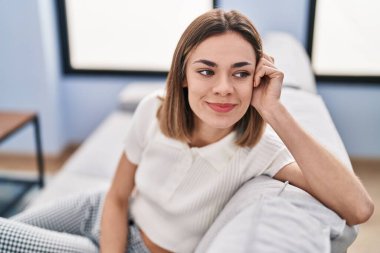 Evdeki kanepede oturan kendine güvenen güzel İspanyol kadın.