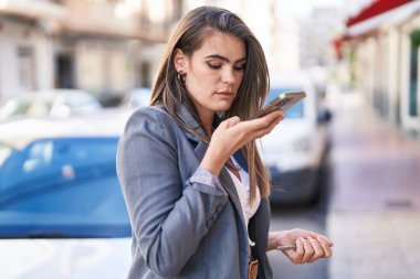 Sokakta akıllı telefondan konuşan genç bir kadın.