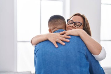 Man and woman mother and son hugging each other at home