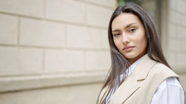 Sokakta ciddi bir ifadeyle duran genç, güzel İspanyol kadın.