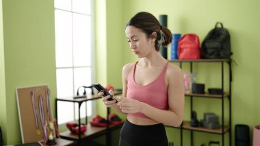 Spor merkezindeki eğitimden sonra akıllı telefon kullanan genç, güzel İspanyol kadın.