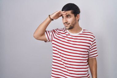 Tecrit edilmiş arka planda duran uzun saçlı İspanyol bir adam. Çok mutlu ve gülümsüyor. Çok uzaklara bakıyor. arama kavramı. 