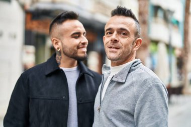 Two men couple smiling confident standing together at street