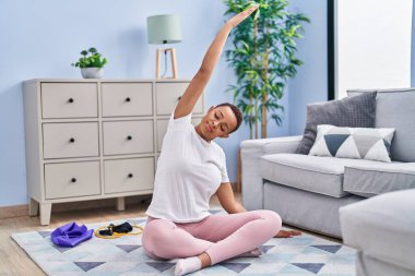 Afrikalı Amerikalı kadın evde yoga eğitimi veriyor.