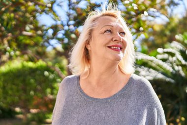 Parkta kendine güvenen orta yaşlı sarışın bir kadın.