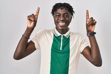 Münzevi arka planda duran Afrikalı adam şaşırmış, şaşırmış ve parmaklarıyla işaret ederek kollarını kaldırdı.. 