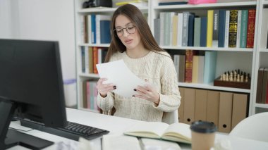 Kütüphane Üniversitesi 'nde evrak okuyan güzel İspanyol bir kadın öğrenci.