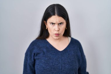 Tecrit edilmiş arka planda duran esmer kadın şüpheci ve gergin, sorun yüzünden surat asıyor. negatif kişi. 