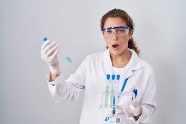 Genç beyaz kadın laboratuvar örnekleriyle çalışıyor. Şaşırmış ve şaşırmış bir ifade, korku ve heyecan dolu bir yüz.. 