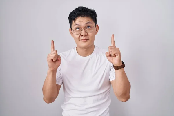 Jovem Asiático Homem Sobre Fundo Branco Apontando Para Cima Olhando — Fotografia de Stock