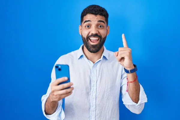 一个留着胡子的西班牙裔男人用智能手机输入消息 指指点点地说出了成功的想法 又兴奋又快乐第一大 — 图库照片