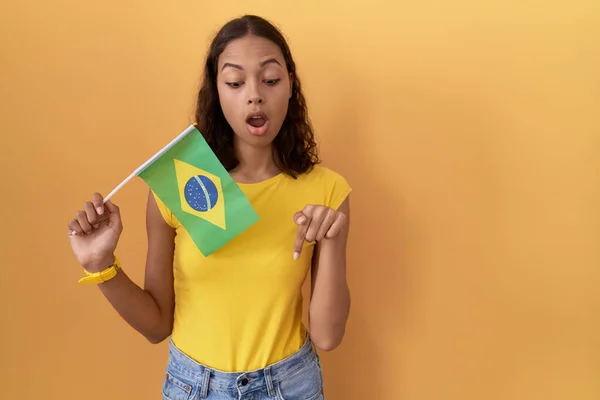 Молодая Латиноамериканка Бразильским Флагом Указывающая Пальцами Рекламу Удивленное Лицо Открытый — стоковое фото