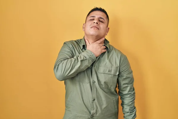 Jovem Hispânico Sobre Fundo Amarelo Tocando Pescoço Doloroso Dor Garganta — Fotografia de Stock