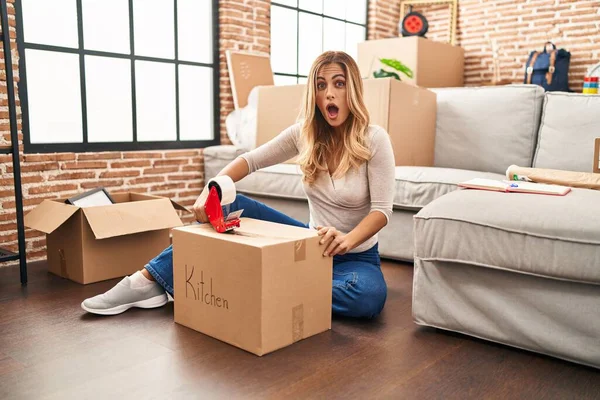 Young Blonde Woman Sitting Floor Closing Boxes Home Scared Amazed — Stock Photo, Image