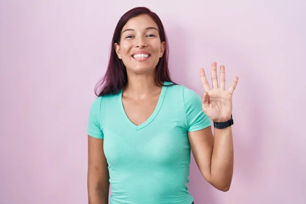 Mladá Hispánka Stojící Nad Růžovým Pozadím Ukazující Ukazující Prsty Číslo — Stock fotografie