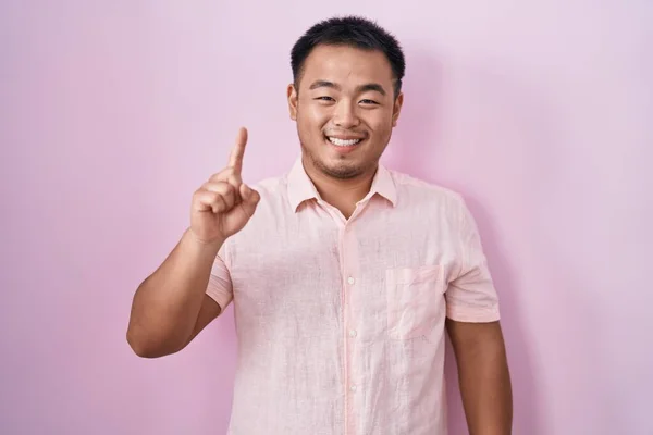 Chinese Young Man Standing Pink Background Showing Pointing Finger Number — Stock Photo, Image