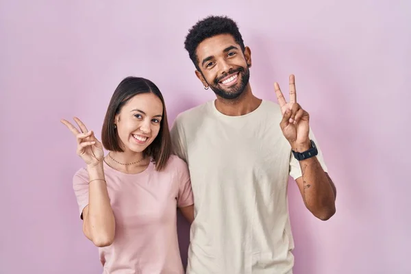 Junges Hispanisches Paar Zusammen Auf Rosa Hintergrund Lächelnd Die Kamera — Stockfoto