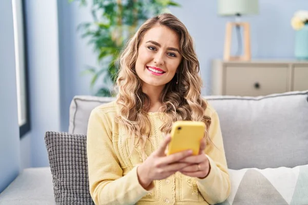 Jonge Vrouw Met Behulp Van Smartphone Zittend Bank Thuis — Stockfoto