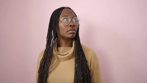 Африканская Женщина Стоящая Сбоку Серьезным Выражением Лица Очках Изолированном Розовом — стоковое фото
