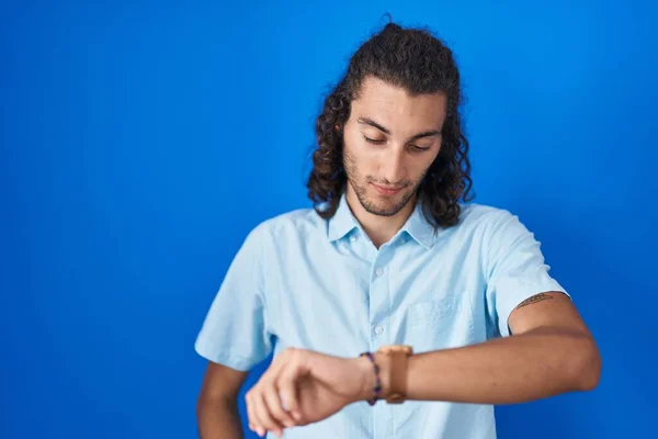 Young Hispanic Man Standing Blue Background Checking Time Wrist Watch — Φωτογραφία Αρχείου