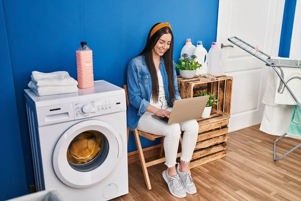 Young Beautiful Hispanic Woman Using Laptop Waiting Washing Machine Laundry — Fotografia de Stock