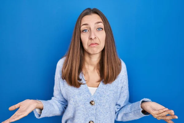 Young Woman Standing Blue Background Clueless Confused Open Arms Idea — Stock Fotó