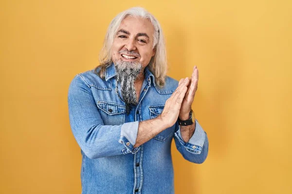 Sarı Arka Planda Gri Saçlı Orta Yaşlı Bir Adam Alkışlıyor — Stok fotoğraf