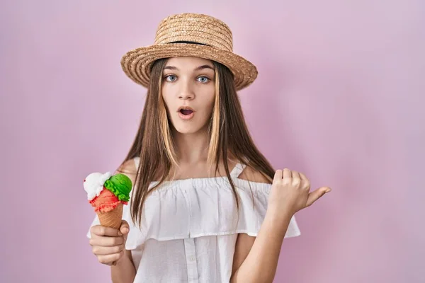 十代の女の子を保持しているアイスクリーム驚きのポインティングとともに手指へ側 口を開けてびっくり式 — ストック写真