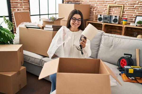 Young Hispanic Woman Smiling Confident Unpacking Cardboard Box New Home — 스톡 사진
