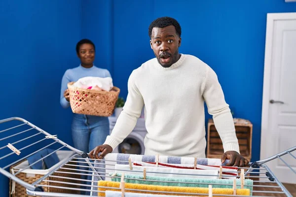 Young African American Couple Hanging Clothes Clothesline Scared Amazed Open — Stock Photo, Image