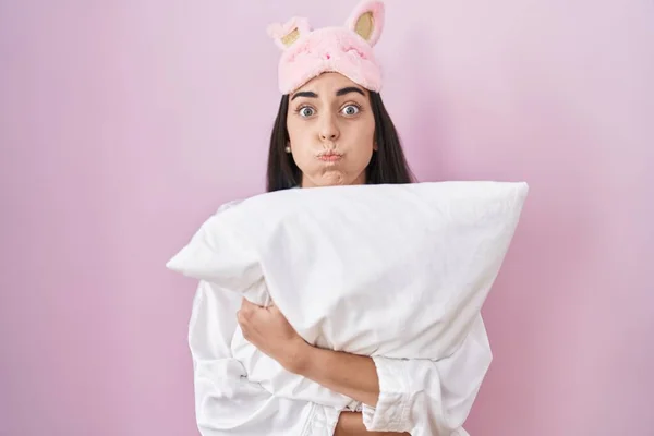 Jovem Morena Usando Máscara Sono Pijama Abraçando Almofada Soprando Bochechas — Fotografia de Stock