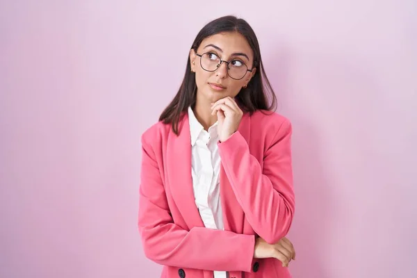 若いヒスパニック系の女性のビジネス服や眼鏡を手であごの質問については 包括的な表現を考えて身に着けている 思慮深い顔で笑顔 疑わしい概念 — ストック写真