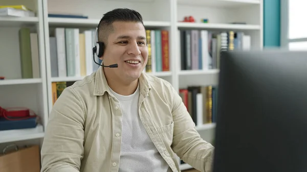 Young hispanic man student smiling confident having video call at library university