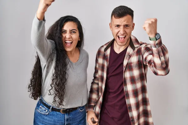 Young Hispanic Couple Standing White Background Angry Mad Raising Fist — 图库照片