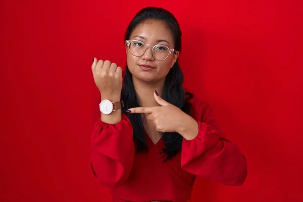 Azjatka Młoda Kobieta Stojąca Nad Czerwonym Tłem Pośpiechu Wskazując Czas — Zdjęcie stockowe