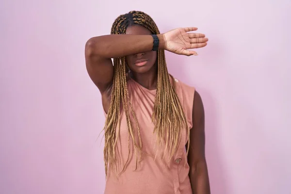 Африканская Американка Плетеными Волосами Стоящими Розовом Фоне Закрывая Глаза Рукой — стоковое фото