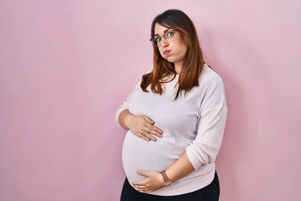 Zwangere Vrouw Staat Roze Achtergrond Puffende Wangen Met Grappig Gezicht — Stockfoto