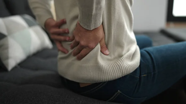 Young Hispanic Man Suffering Backache Sitting Sofa Home — Stok fotoğraf