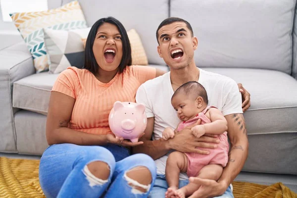 Jong Hispanic Paar Met Baby Holding Spaarvarken Bank Boos Gek — Stockfoto