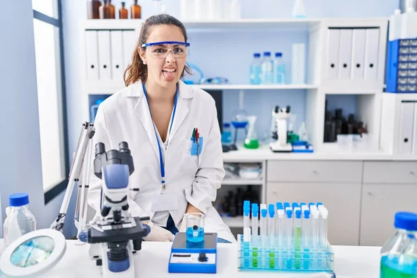 Young Hispanic Woman Working Scientist Laboratory Sticking Tongue Out Happy — Stock Photo, Image