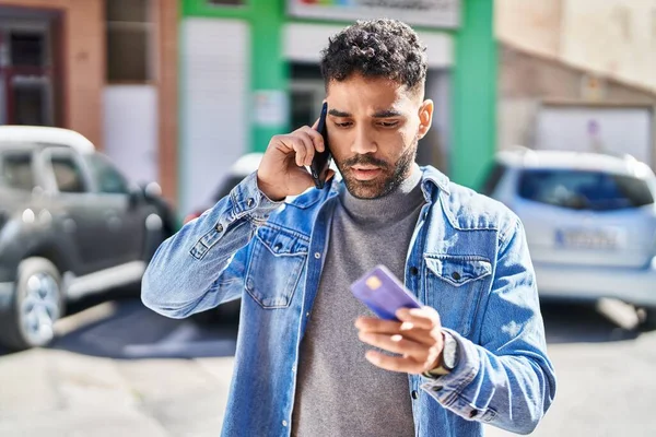 Young Hispanic Man Talking Smartphone Using Credit Card Street — Stock Fotó
