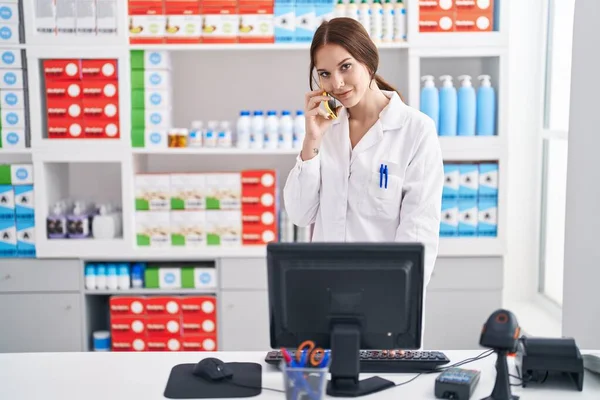 Молодая Женщина Фармацевт Разговаривает Смартфоне Работая Аптеке — стоковое фото