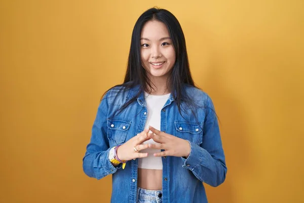 Mladá Asiatka Stojící Nad Žlutýma Rukama Pozadí Zkřížené Prsty Uvolněně — Stock fotografie