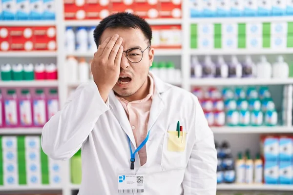 Китайский Молодой Человек Работающий Аптеке Зевает Усталости Прикрывая Рукой Половину — стоковое фото