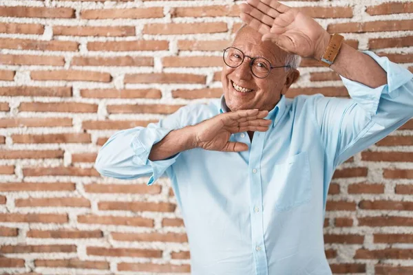 Starszy Mężczyzna Siwymi Włosami Stojący Nad Cegłami Uśmiechnięty Radosny Grający — Zdjęcie stockowe