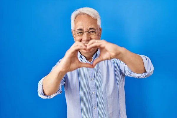 Hispanic Senior Man Wearing Glasses Smiling Love Doing Heart Symbol — Stock fotografie