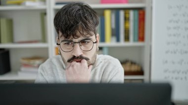 Üniversite sınıfında bilgisayar kullanan genç bir İspanyol.