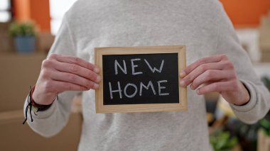 Yeni evinde tahtası olan Latin asıllı genç bir adam.