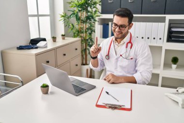 Sakallı genç İspanyol doktor klinikte randevusu var. Bir fikir veya soru işareti ile gülümsüyor. 