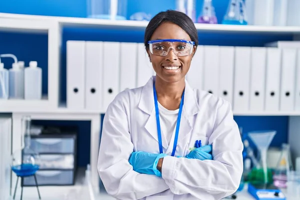 若いアフリカ系アメリカ人女性科学者は自信を持って立って笑顔で腕を組んでジェスチャーで実験室 — ストック写真